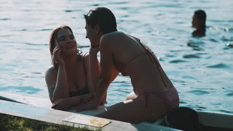 two women relaxing on a boat by the lake