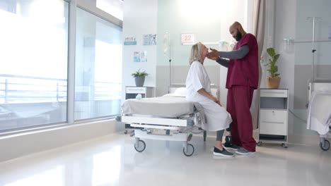 médico afroamericano examinando la cara de una paciente caucásica en el hospital