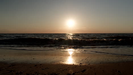 sunset over dark bay with waves in slow motion
