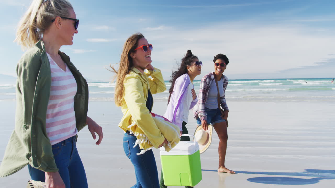 счастливая группа разнообразных подруг-женщин веселится, гуляет по пляжу