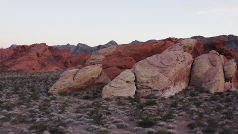 Point-of-interest-aerial-drone-shot-of-Nevada's-Red-Sandstones-revealing-the-hills-in-the-background