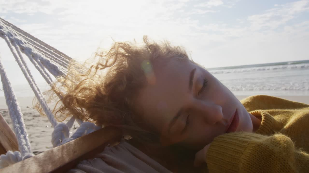 Kvinde sover i hængekøje på stranden 4k
