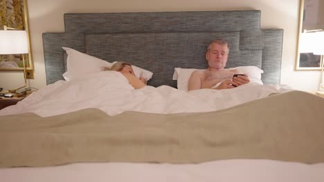Naked couple chatting in bed before man decides to get up, locked off