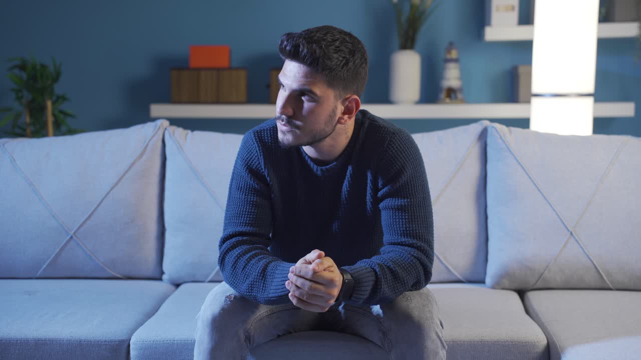 Depressed and anxious man thinking at home.