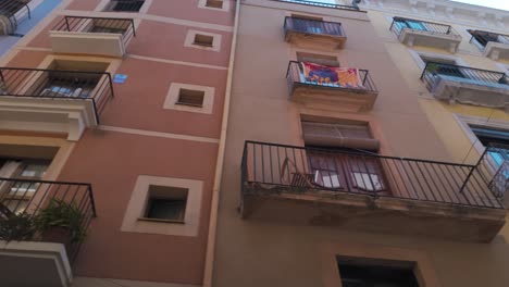 historic yellow buildings with wrought-iron balconies in a narrow street in tarragona spain