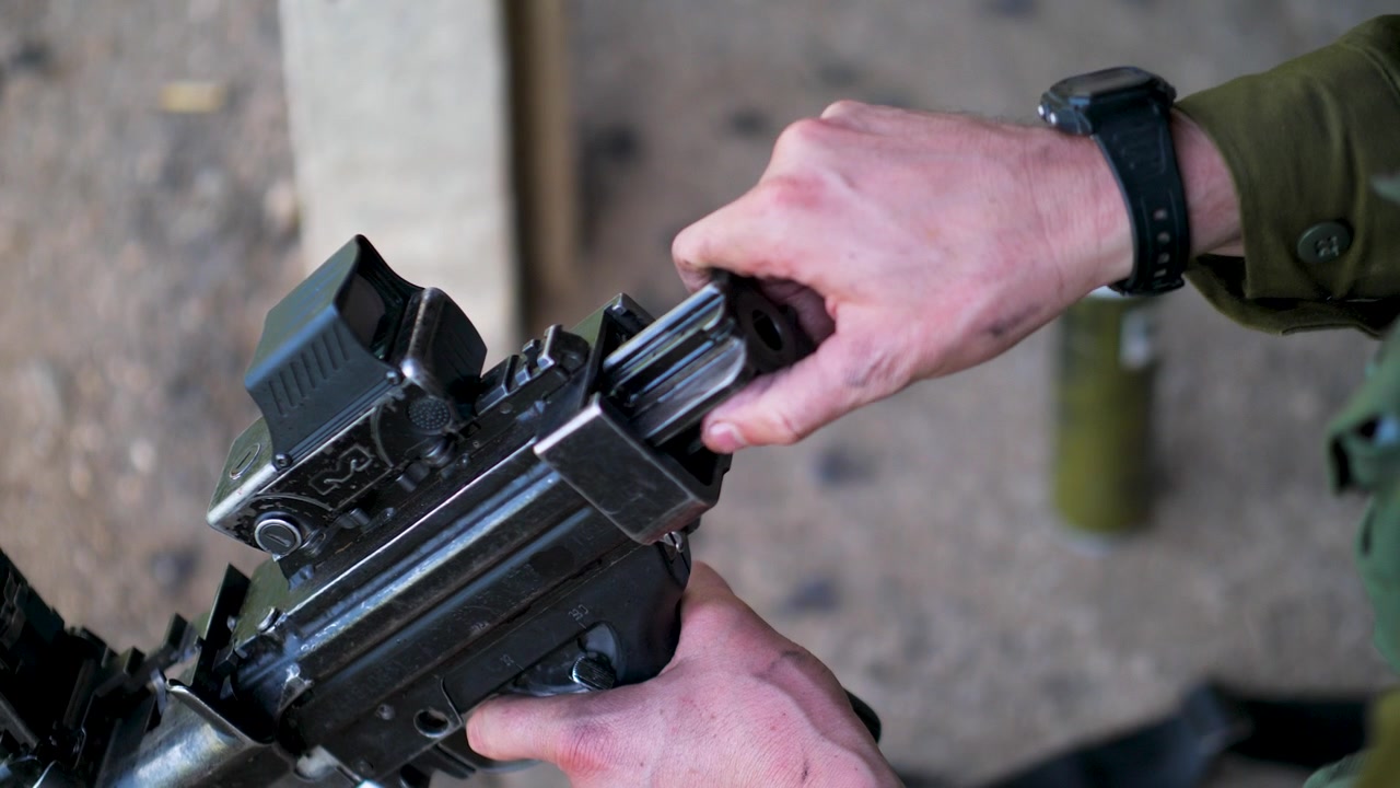 Israeli army soldier removes rifle bolt carrier during maintenance handling