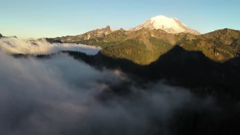 aerial view of sunny mount rainier and clouds above valley, washington state usa