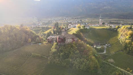 video aéreo de drones de un castillo medieval en medio de los viñedos en los alpes italianos