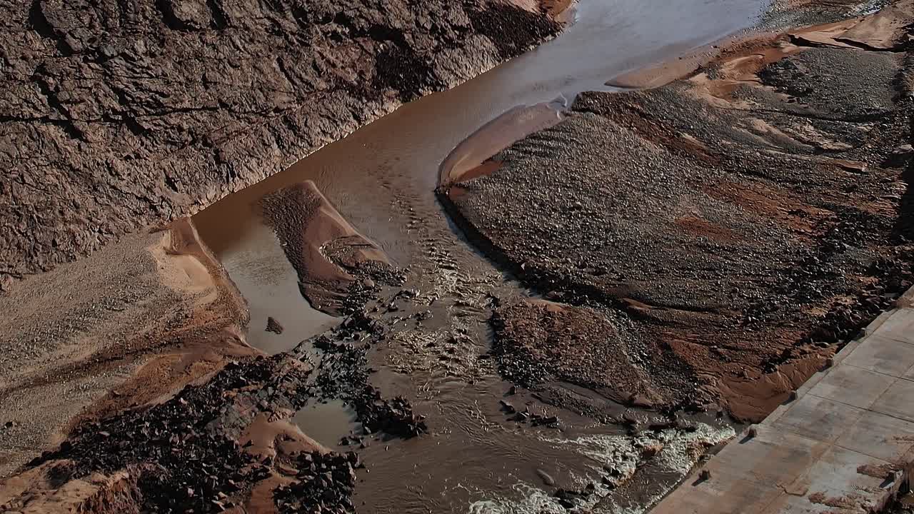 Aerial view of a dry riverbed in Morocco with rocky terrain and water