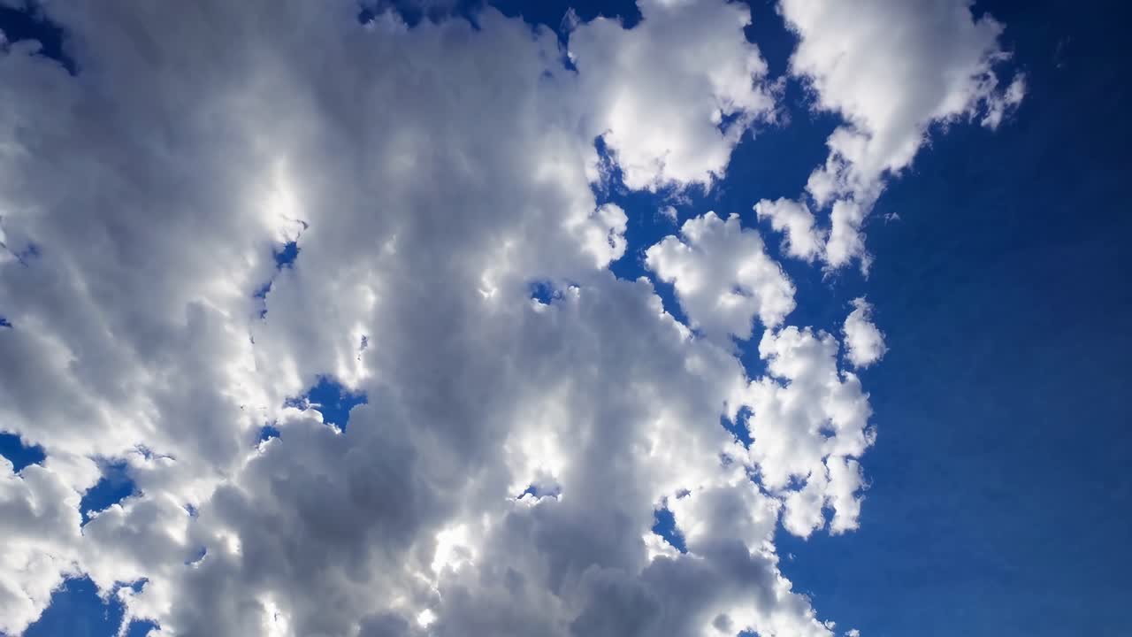 Video captures a serene sky with fluffy clouds from a low-angle perspective