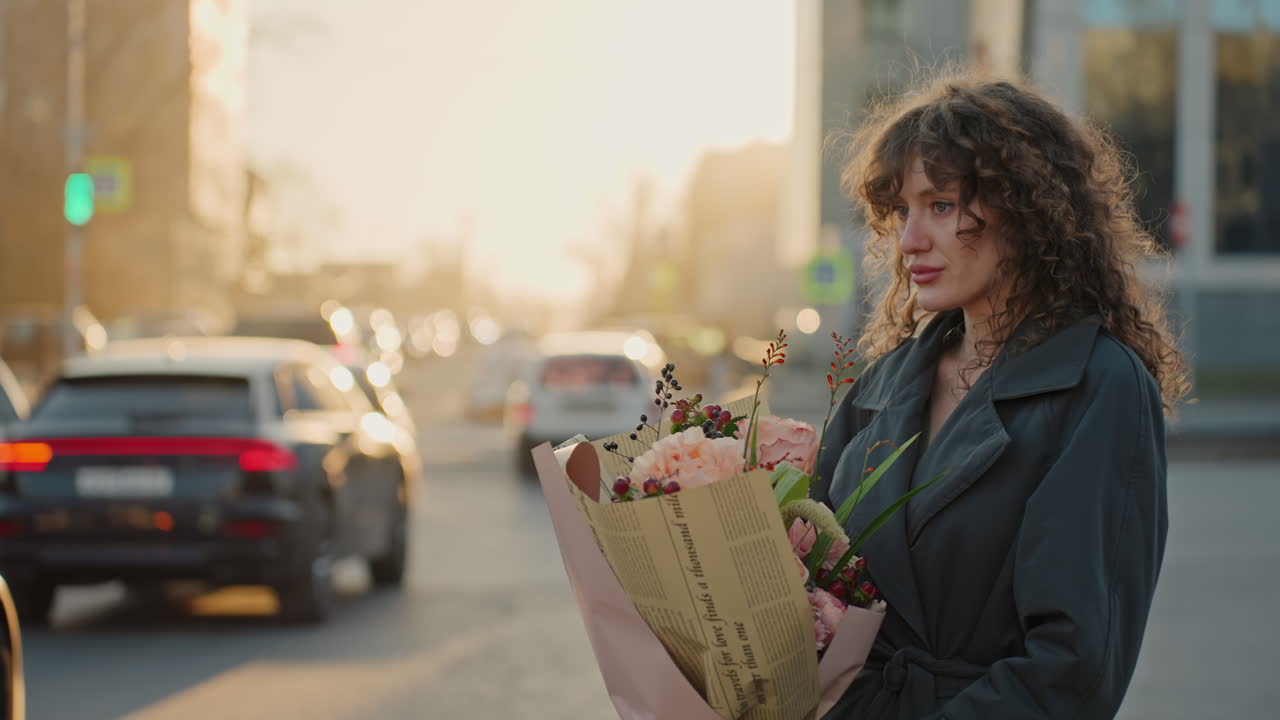 Kvinde med levende buket under solnedgang. Selvsikker kvinde holder et farverigt blomsterarrangement udendørs. En kvinde holder selvsikkert en strålende buket blomster i et livligt bybillede ved skumringstid.