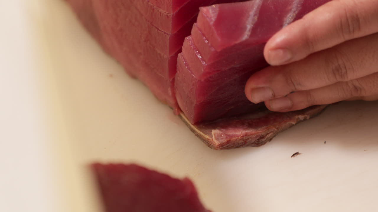 Skilled Chef Slicing A Fresh Tuna On A Chopping Board In The Kitchen Of A Japanese Restaurant
