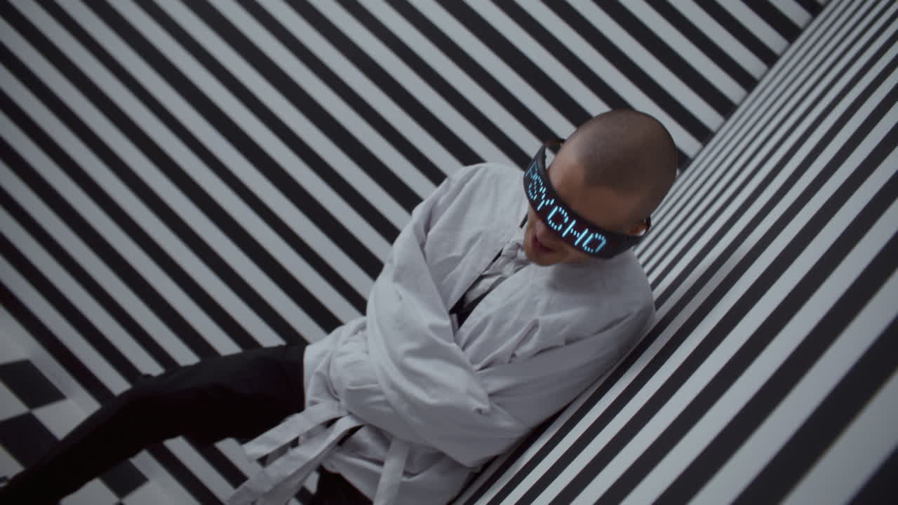 Person in a Straight Jacket with Digital Glasses in a Striped Room