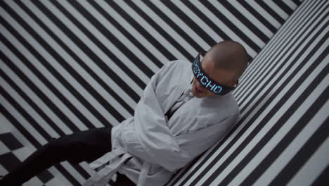 person in a straight jacket with digital glasses in a striped room