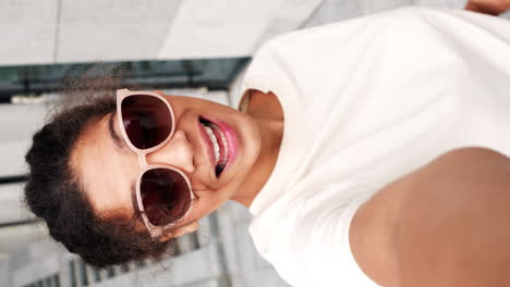 chica tomando una selfie con un signo de paz y gafas de sol