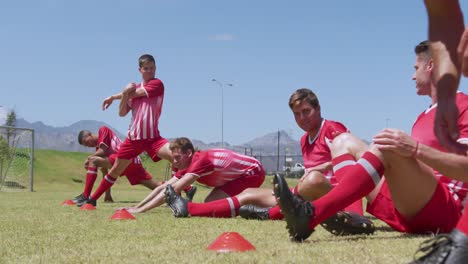 jugadores de fútbol estirándose antes del entrenamiento