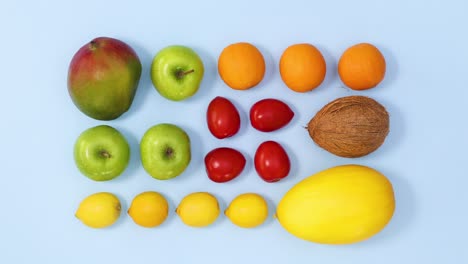 vibrant layout made of fresh ripe fruits move on bright blue background. stop motion flat lay