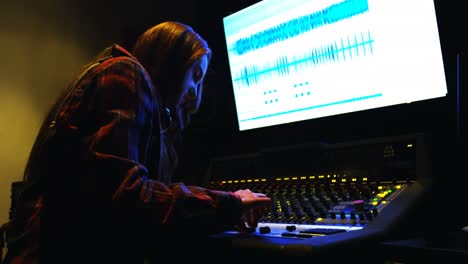 Female-audio-engineer-using-sound-mixer