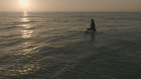 apple prores 422 surfer girl sitting on longboard and watching the sunset sunrise over the atlantic at fuerteventura canary islands filmed with dji mavic 3 cine