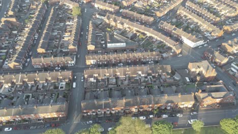 aerial view above typical british neighbourhood housing estate at sunrise ascending birds eye shot