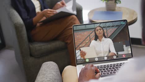 african american businessman using laptop for video call with biracial business colleague