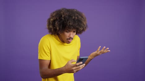 Man with Afro Hair Reacting to Something on His Smartphone