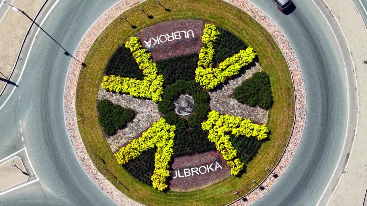 Veduta aerea simmetrica di una rotonda moderna circondata da veicoli in movimento
