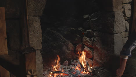 Atmospheric-shot-of-dark-masonry-kitchen-and-housewife-cooking-in-a-rustic-pot