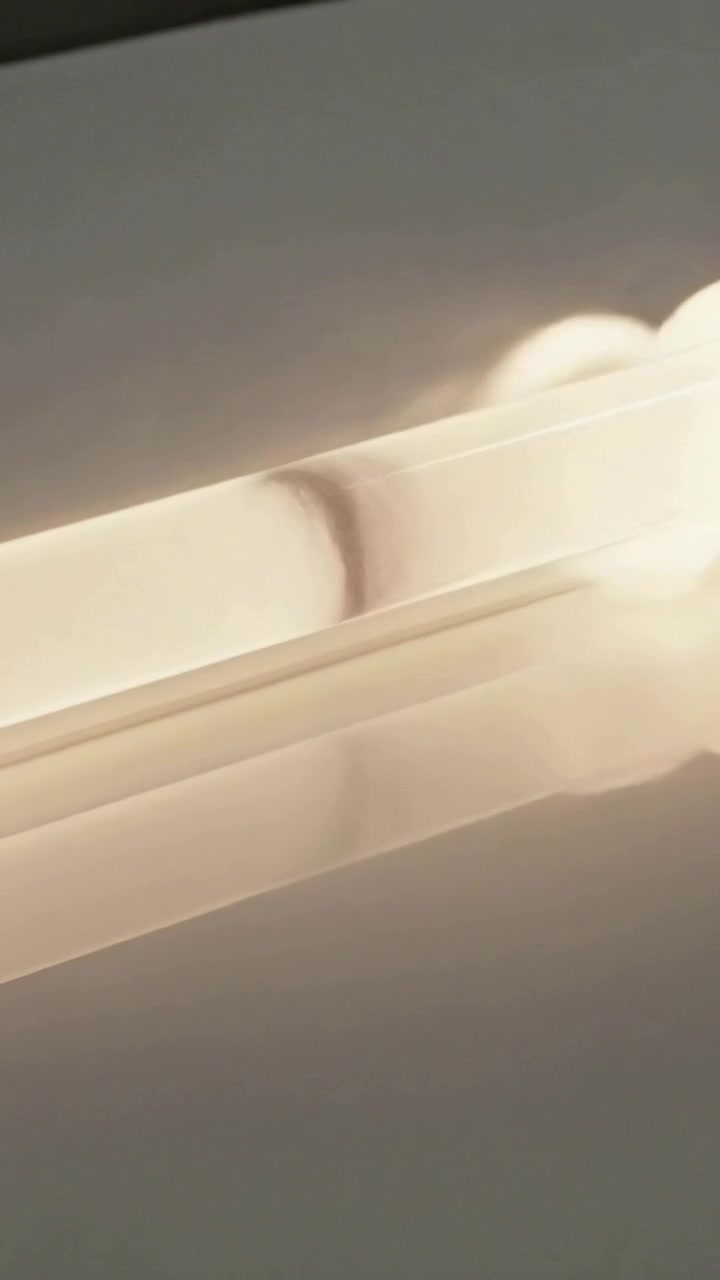 Vertical video: Appearing at right, specular hotspot moving left across long LED strip
