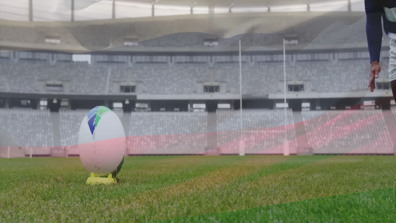 Player in stadium preparing to kick rugby ball on tee with focus