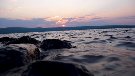 lago de piedra amarilla al atardecer con piedras en primer plano