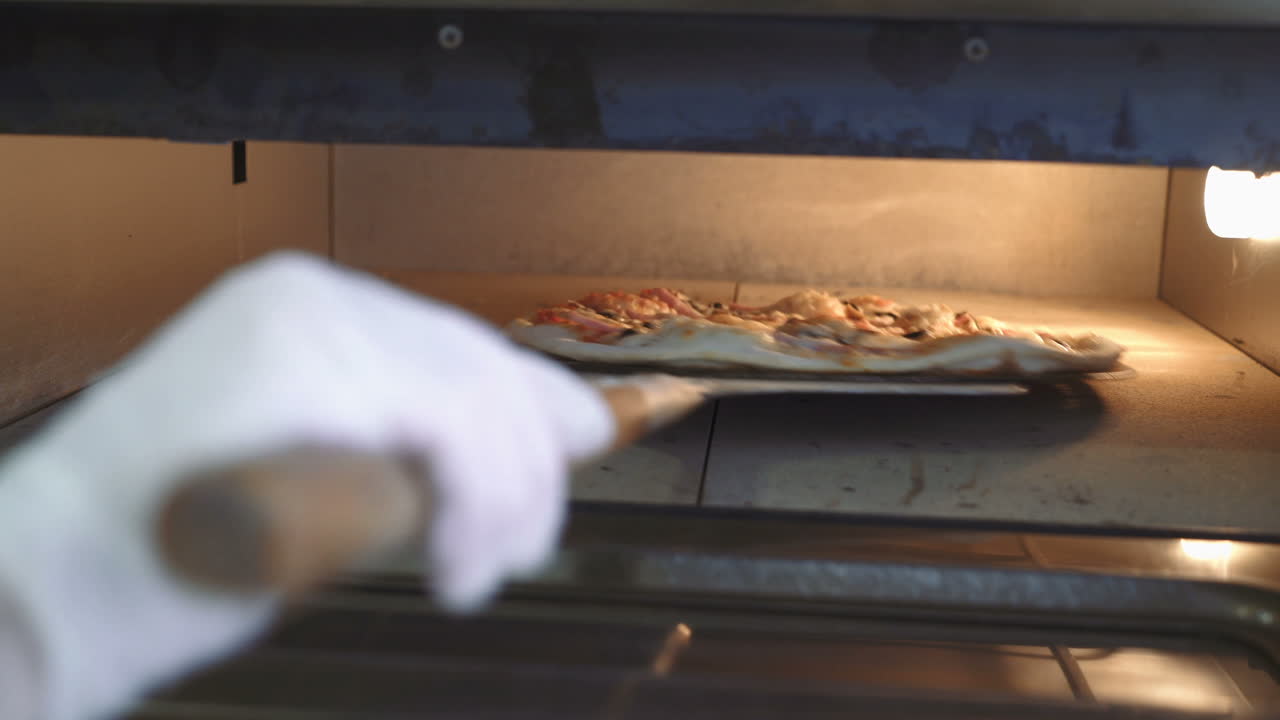 Chef puts a raw pizza into the oven. Making pizza. Cooking food.
