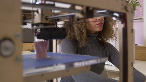 female designer working with 3d printer in a design studio, shot on r3d