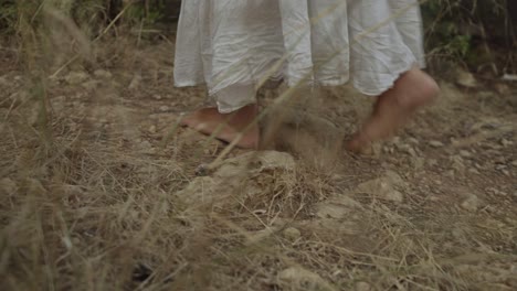 a barefood woman is walking through the forest