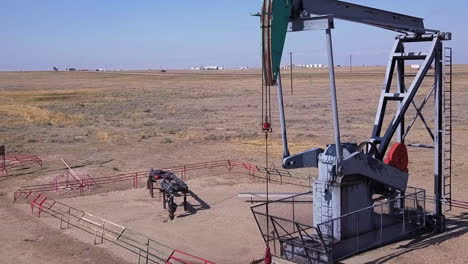 bluejack bombea petróleo en un terreno llano de la pradera cerca de la carretera rural