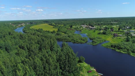 aerial view of a river flowing through a village and forest