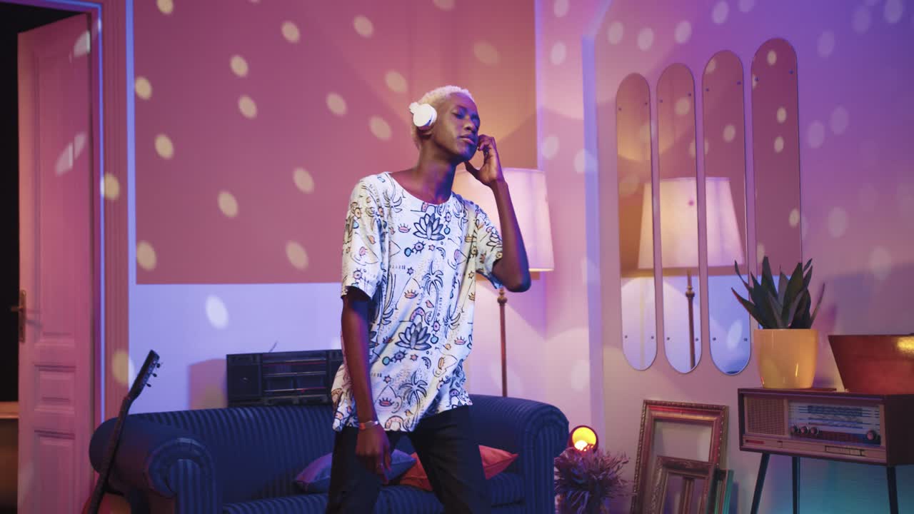 집에서 복고풍 파티에서 헤드폰을 끼고 춤을 추는 아프리카 계 미국인 편안한 남자