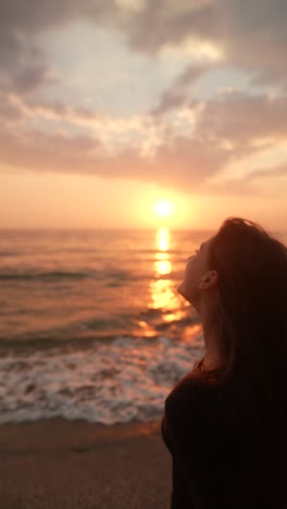 woman enjoying a sunrise/sunset at the beach