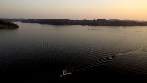 Flying-over-a-small-boat-at-sunset-above-the-Tennessee-River