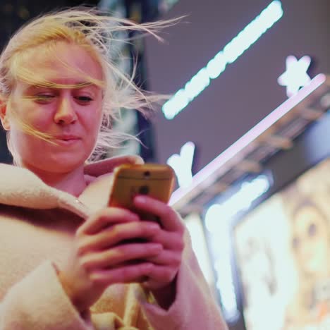 young woman in pink coat typing sms on the phone 3