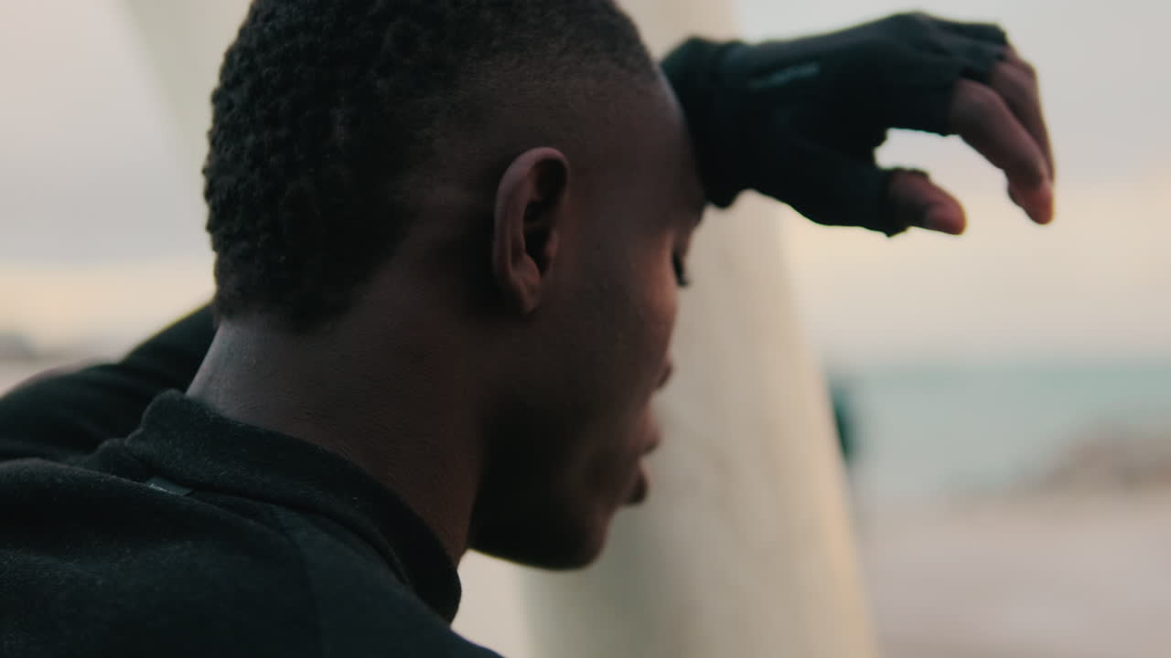 Thoughtful Young Black Man Resting by the Ocean