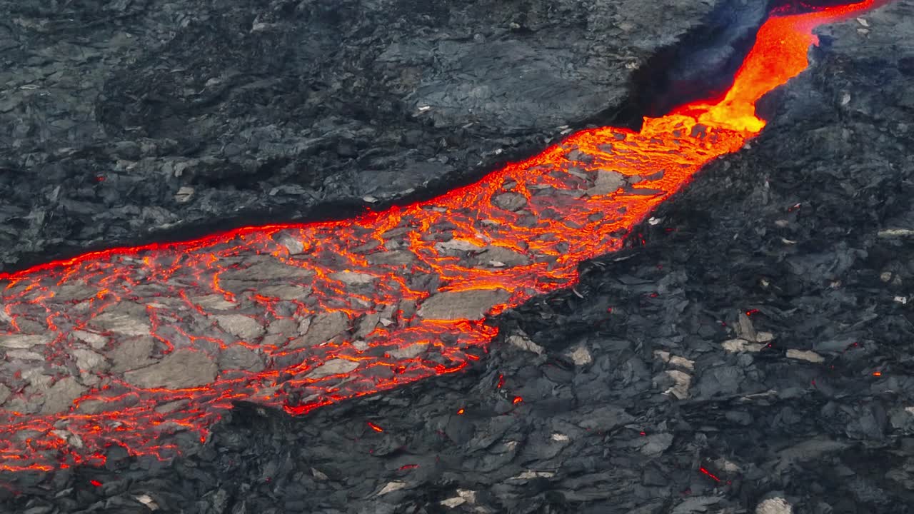 vista aérea de cerca de las texturas de las corrientes de lava, provenientes de las erupciones volcánicas en litli-hrutur, islandia, con humo subiendo