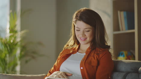 pregnant woman using tablet at home