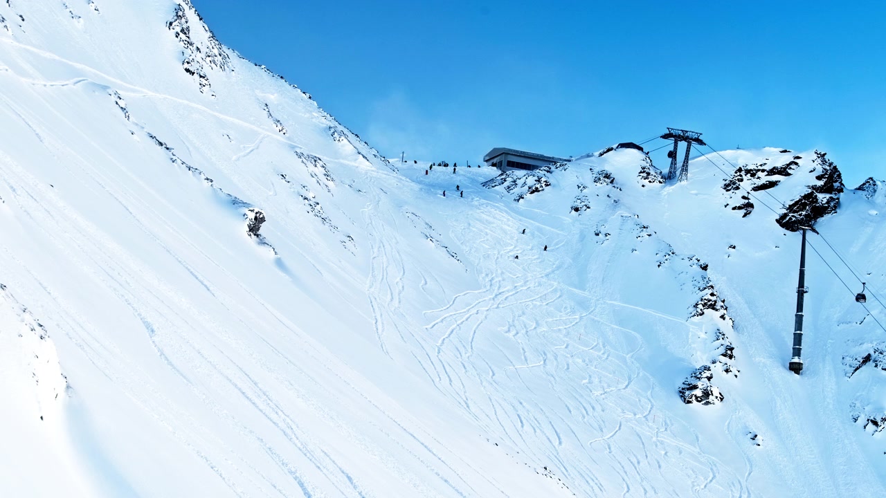 Timelapse overlooking the Tortin sector in Verbier as freeriders carve fresh lines across deep powder beneath the ski lifts on a perfect powder day.
