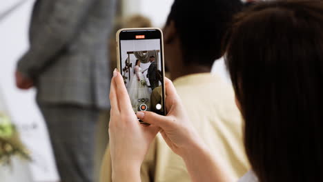 Guest-using-smartphone-at-the-ceremony