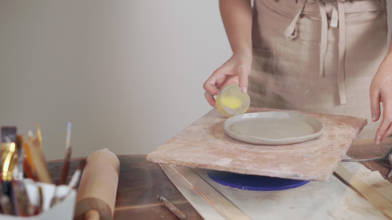 mujer haciendo un plato de arcilla en una rueda de cerámica