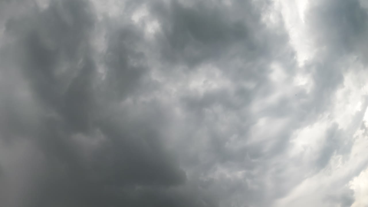 Dark stormy clouds gathering in the sky. Raindrops falling on the camera. View from below. Timelapse.