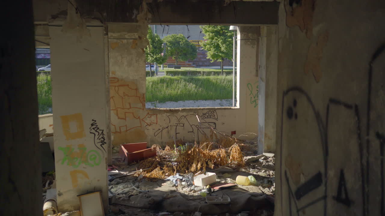 Tilt Up Interior of abandoned building in Sarajevo, Bosnia. See through window to outside grass trees