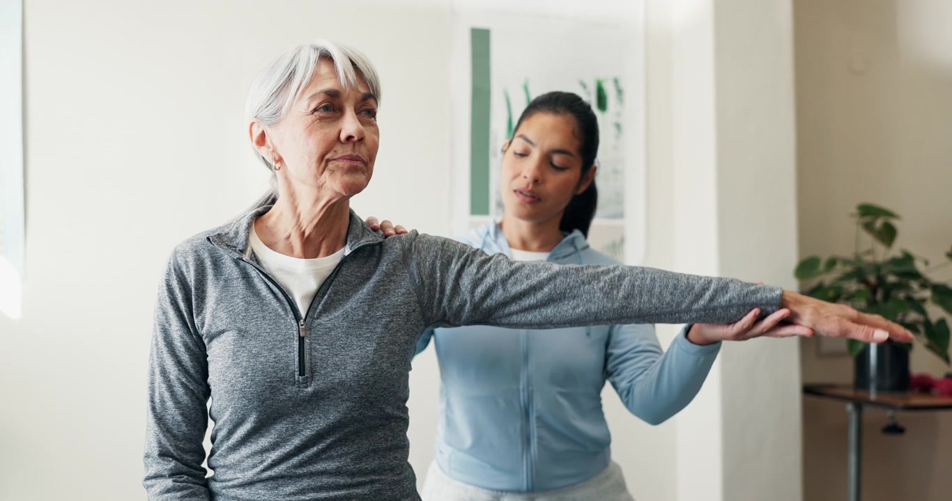 Physical Therapist Assisting Senior Woman with Arm Stretching Exercise