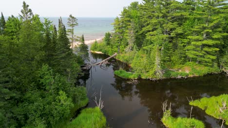 aerial orbit of wooded lake inlet, lake superior, michigan